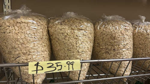 Egusi melon seeds in large clear bags on shelf with $35.99 price tag